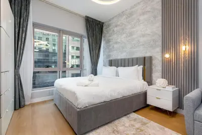 a bedroom with a large bed and a window at White Sage Stunning New Studio in Marina in Dubai