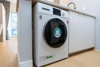 a white washing machine sitting in a room at White Sage Stunning New Studio in Marina in Dubai