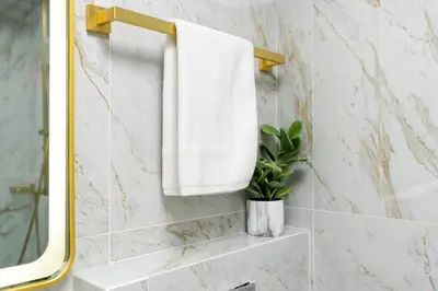 a bathroom with a white towel and a mirror at White Sage Stunning New Studio in Marina in Dubai