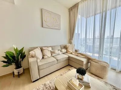 a living room with a couch and a large window at Stylish 1br Apt In Jvc Pool Access & Parking in Dubai