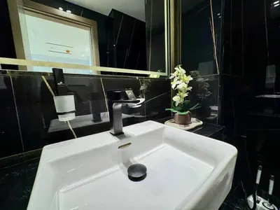 a white sink in a black bathroom with a phone at Stylish 1br Apt In Jvc Pool Access & Parking in Dubai