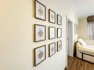 a group of framed pictures on a wall at DreamShoma- Deluxe 1BR With Lake View in Dubai