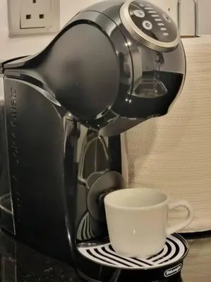 a coffee maker is making a cup of coffee at 2 Bedroom DAMAC Prive Apartment in Dubai