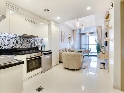 a kitchen with white cabinets and a living room at ALiving Elegant 2BR plus Maid's Room I Aykon City, Business Bay- 4016 in Dubai