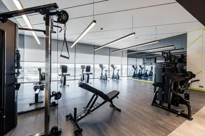 a gym with treadmills and elliptical machines at ALiving Elegant 2BR plus Maid's Room I Aykon City, Business Bay- 4016 in Dubai
