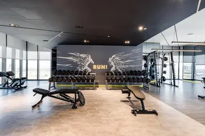 a gym with rows of exercise equipment in a room at ALiving Elegant 2BR plus Maid's Room I Aykon City, Business Bay- 4016 in Dubai