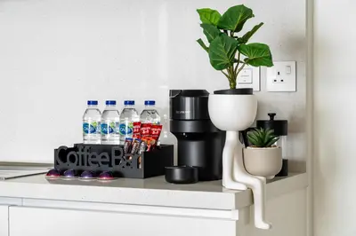 a shelf with bottles of water and a potted plant at Arthouse Views - Burj Khalifa view & Dubai Mall access in Dubai