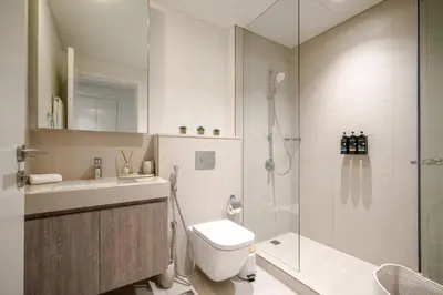 a bathroom with a shower and a toilet and a sink at Arthouse Views - Burj Khalifa view & Dubai Mall access in Dubai