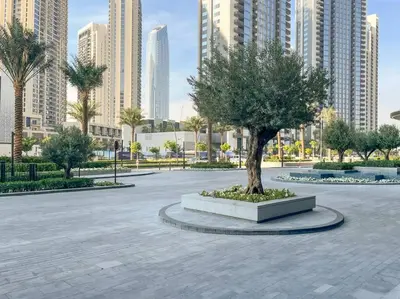 a tree in the middle of a park with tall buildings at Waves - Luxurious 11th Floor Retreat in Palace Residences in Dubai