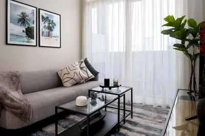 a living room with a couch and a table at Waves - Canal-View Elegance 1BR Apt in Reva Residences in Dubai
