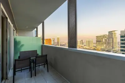 a balcony with a table and chairs and a view of a city at Waves - Canal-View Elegance 1BR Apt in Reva Residences in Dubai