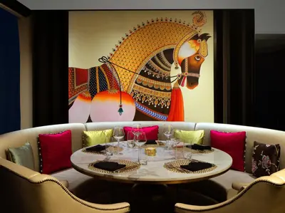 a dining room with a table and a painting on the wall at Taj Dubai in Dubai