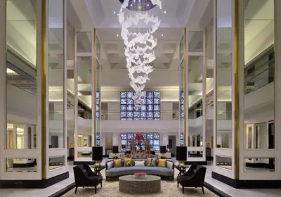 a lobby with a chandelier and a couch and chairs at Taj Dubai in Dubai