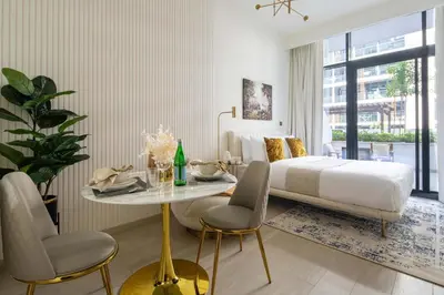a bedroom with a bed and a table and chairs at Frank Porter - Azizi Riviera 28 in Dubai