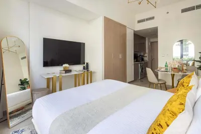 a bedroom with a large white bed and a television at Frank Porter - Azizi Riviera 28 in Dubai
