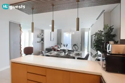 a kitchen and living room with a counter and a living room at HiGuests - Beachside Oasis Stylish 2BR Apartment in La Vie in Dubai