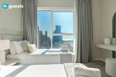 a hotel room with a bed and a large window at HiGuests - Beachside Oasis Stylish 2BR Apartment in La Vie in Dubai