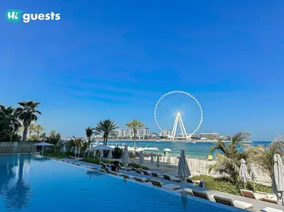 a large swimming pool with a ferris wheel in the background at HiGuests - Beachside Oasis Stylish 2BR Apartment in La Vie in Dubai