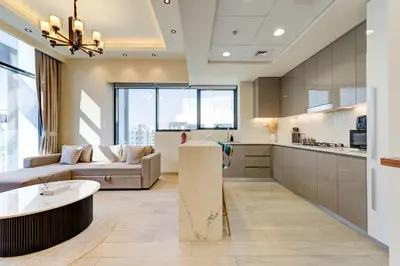 a large kitchen and living room with a couch and a table at Chic 1 Bed Oasis in Azizi Riviera in Dubai