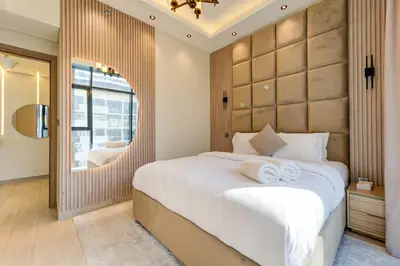a bedroom with a large white bed and a window at Chic 1 Bed Oasis in Azizi Riviera in Dubai