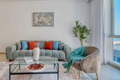 a living room with a couch and a glass table at Artistic Retreat in JBR with Private Beach Access in Dubai