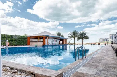 a large swimming pool with a building in the background at Artistic Retreat in JBR with Private Beach Access in Dubai