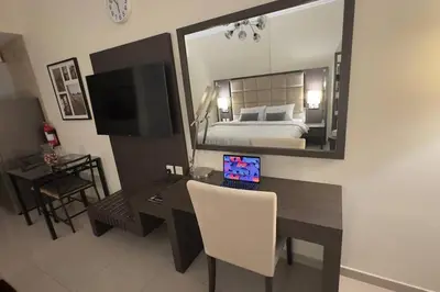 a bedroom with a desk with a bed and a mirror at Stylish Studio With Amazing View in Dubai