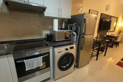 a kitchen with a washing machine and a refrigerator at Stylish Studio With Amazing View in Dubai