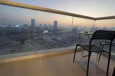 a table and a chair in a room with a window at Stylish Studio With Amazing View in Dubai