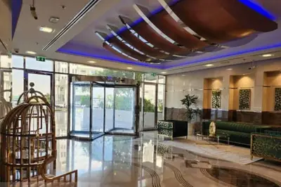 a lobby of a building with a green couch at Stylish Studio With Amazing View in Dubai