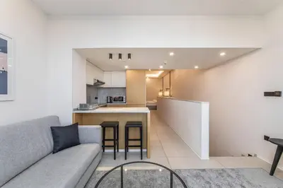 a living room with a couch and a kitchen at Palm Jumeirah Studio Sea View Royal Amwaj in Dubai
