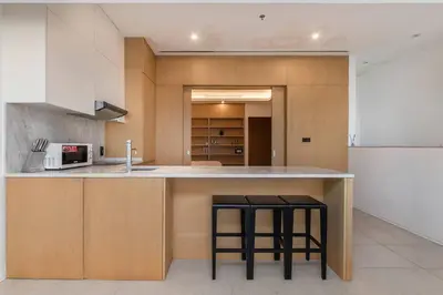 a kitchen with two bar stools and a counter top at Palm Jumeirah Sea View 1Bdr in Dubai
