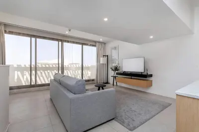 a living room with a couch and a flat screen tv at Palm Jumeirah Sea View 1Bdr in Dubai