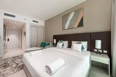 a bedroom with a large white bed with towels on it at Private Beach Palm Jumeirah Studio high floor in Dubai