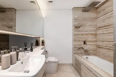 a bathroom with a tub and a toilet and a sink at Downtown Studio Sterling WEST in Dubai