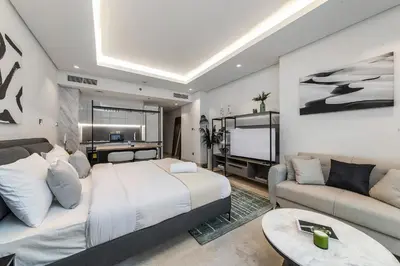 a bedroom with a bed and a couch and a tv at Downtown Studio Sterling WEST in Dubai