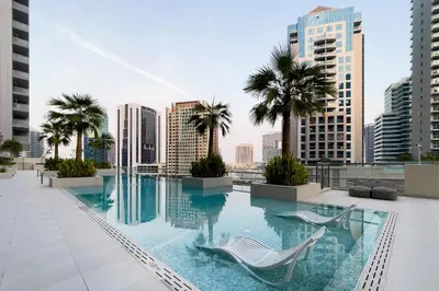 a pool on the roof of a building with palm trees at Downtown Studio Sterling WEST in Dubai