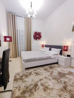 a bedroom with a large bed and a chandelier at Elegant Fresh 1BR with Heated Pool, just steps from Mall, Restaurants & Fitness center in Dubai