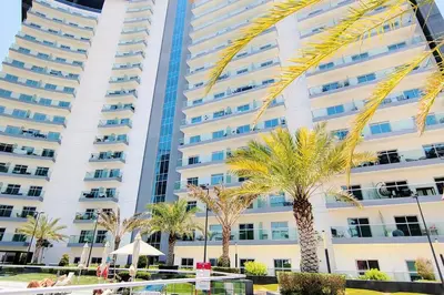 a tall building with palm trees in front of it at Best Place 2B Dubai in Dubai