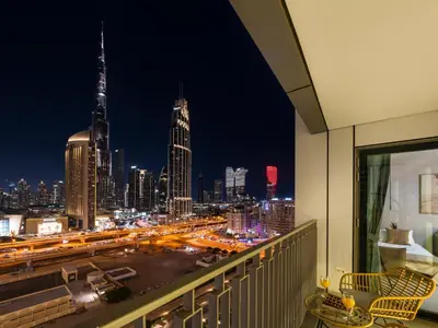 a view of a city skyline at night from a balcony at Premium Two-Bedroom Apartment with Private Balcony & Full Burj Khalifa Views by Al Fannan Holiday Homes in Dubai