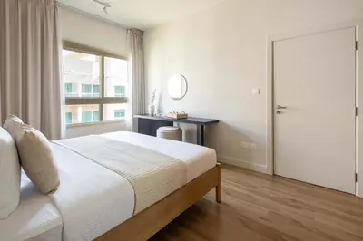 a bedroom with a bed and a mirror and a window at Frank Porter - Al Dhafrah 2 in Dubai
