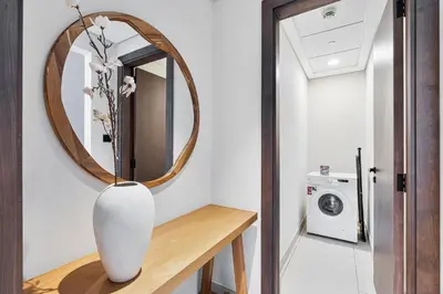 a vase sitting on a table in front of a mirror at Modern 2 BR Apartment near Dubai Butterfly Garden in Dubai