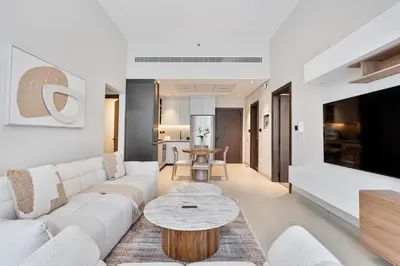 a living room with a white couch and a table at Modern 2 BR Apartment near Dubai Butterfly Garden in Dubai