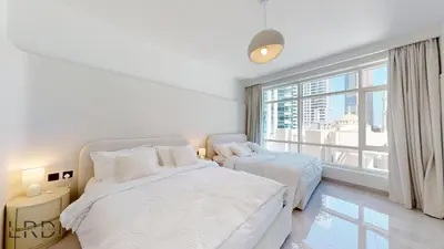 a bedroom with two beds and a large window at Luxurious Apartment with Marina Views in Dubai