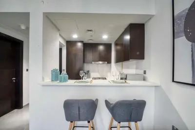 a kitchen with two chairs and a counter at 1-Bedroom in Merano Tower, Business Bay with City Views in Dubai
