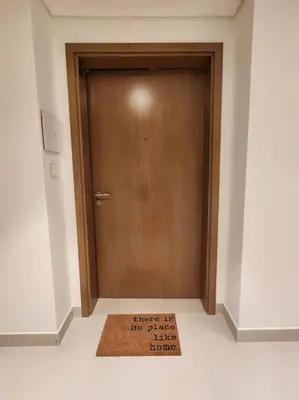 a brown door with a welcome mat in front of it at Your Dubai Home in Dubai