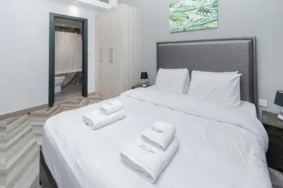 a bedroom with a large white bed with towels on it at Canal View, 1BR, Terrace I Gym, Pool, Parking in Dubai