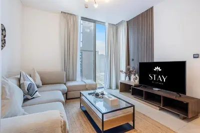 a living room with a couch and a tv at STAY BY LATINEM Luxury 1BR Holiday Home CVR B2303 near Burj Khalifa in Dubai