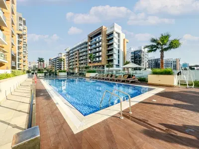 a large swimming pool with buildings in the background at Chic Studio Azizi Riviera Retreat with City Views in Dubai