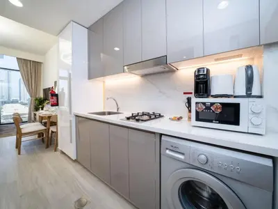 a kitchen with a washing machine and a sink at Chic Studio Azizi Riviera Retreat with City Views in Dubai